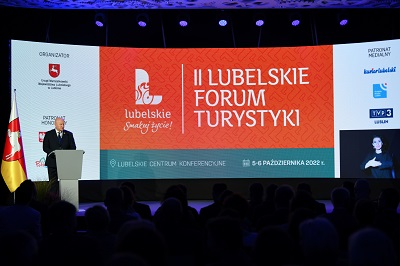 Widok na salę konferencyjną i ekran wyswietlający napis II Lubelskie Forum Turystyki