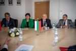 Cztery osoby siedzące przy stole. Na pierwszym planie niewielka flaga Bułgarii