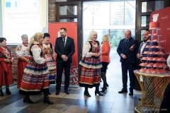 Członkowie Zarządu częstują słodyczami panie z koła gospodyń wiejskich ubrane w stroje ludowe