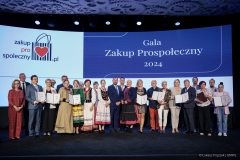 Na scenie pozuje do zdjęcia około 20 laureatów  certyfikatu, za nimi na dużym ekranie wyświetla się napis Gala Zakup Prospołeczny 2024