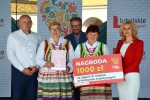 Zdjęcie przedstawia laureatów konkursu stojących na scenie z symbolicznym czekiem wskazującym wartość wygranej nagrody