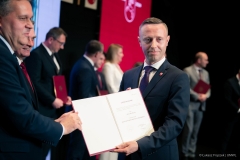 Michał Mulawa pokazuje do fotografa dokument zaświadczający o wyborze na Radnego