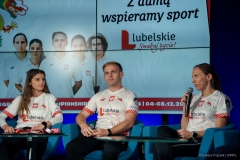 Trzech reprezentantów Polski w zawodach teqball podczas konferencji prasowej, wszyscy siedzą na fotelach za nimi na dużym ekranie wyświetla się napis Z dumą wspieramy sport