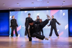 Kilkuosobowy młodzieżowy zespół breakdance podczas występu w sali konferencyjnej