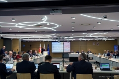 Sala konferencyjna i trwająca sesja sejmiku województwa lubelskiego. Kilkadziesiąt osób siedzi przy dużym stole ustawionym w podkowę