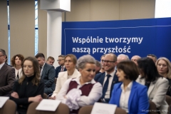 Uczestnicy konferencji na tle  baneru z napisem Wspólnie tworzymy naszą przyszłość